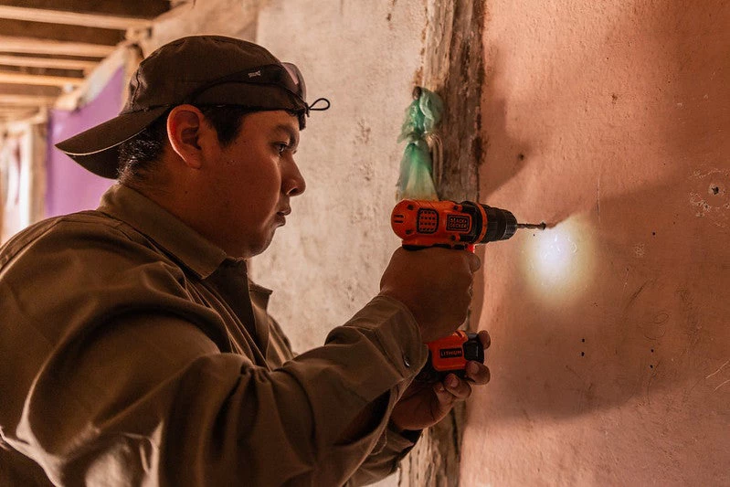 Joven electricista argentino agujereando una pared 