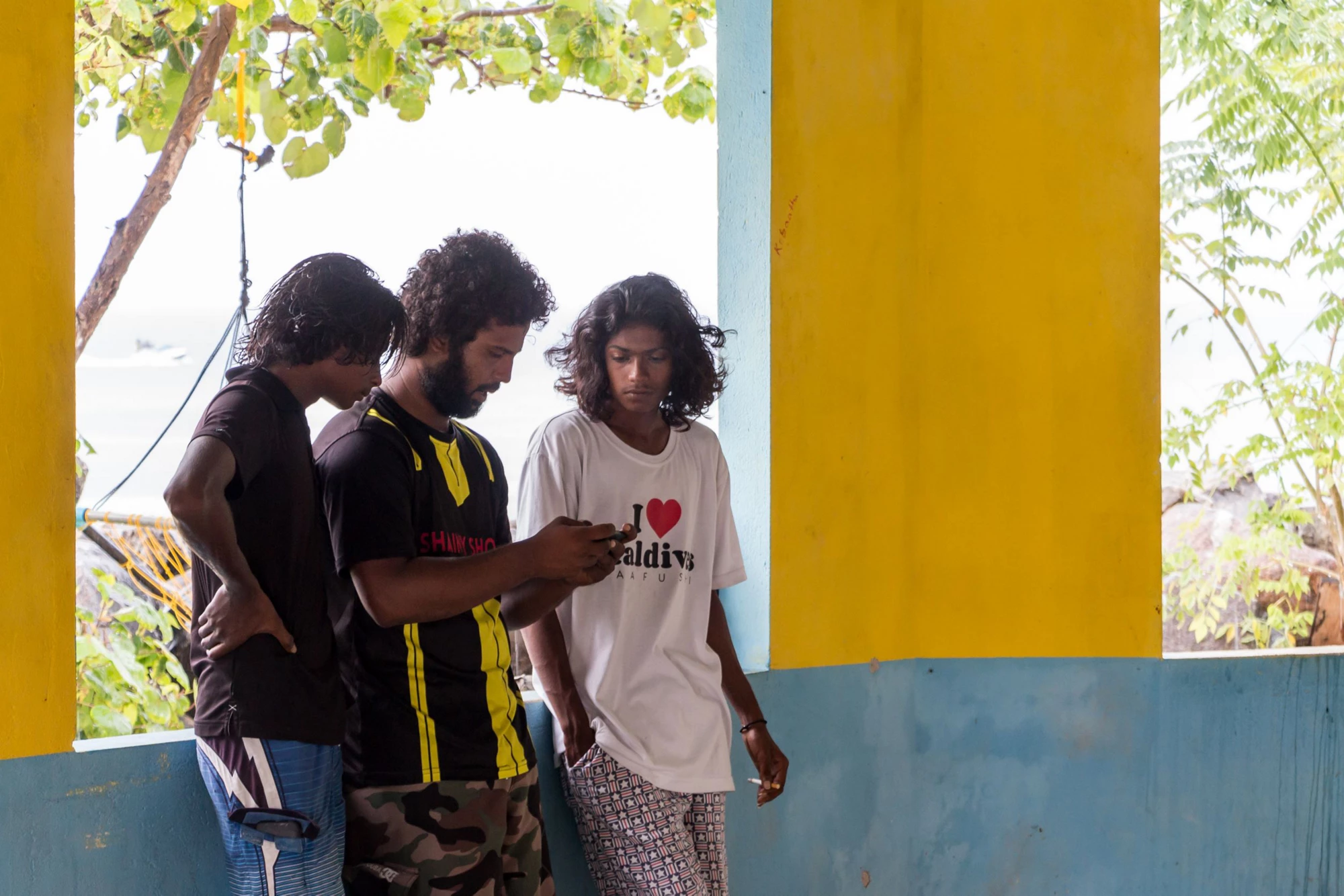 Maldivians look at a cellphone