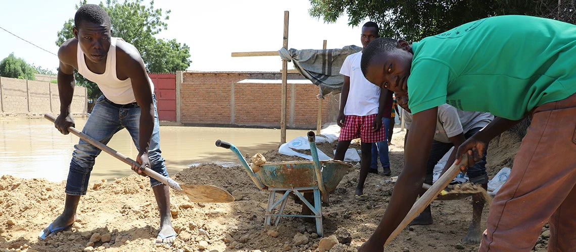 Young men cleaning up after the floods