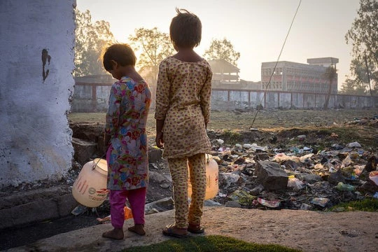 Children stand near the dilapidated premises of Union Carbide in Bhopal, India. (Photo via Bhopal Medical Appeal / Flickr CC)