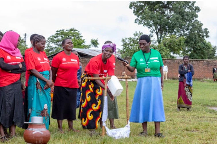 Des femmes montrent comment elles utilisent l’eau au quotidien, notamment pour se laver les mains et cuisiner (Malawi). Le projet d’approvisionnement en eau de Chimbiya a été cofinancé par CIWA. Crédits photo : L’Institut de gestion des eaux souterraines de la Communauté de développement d’Afrique australe