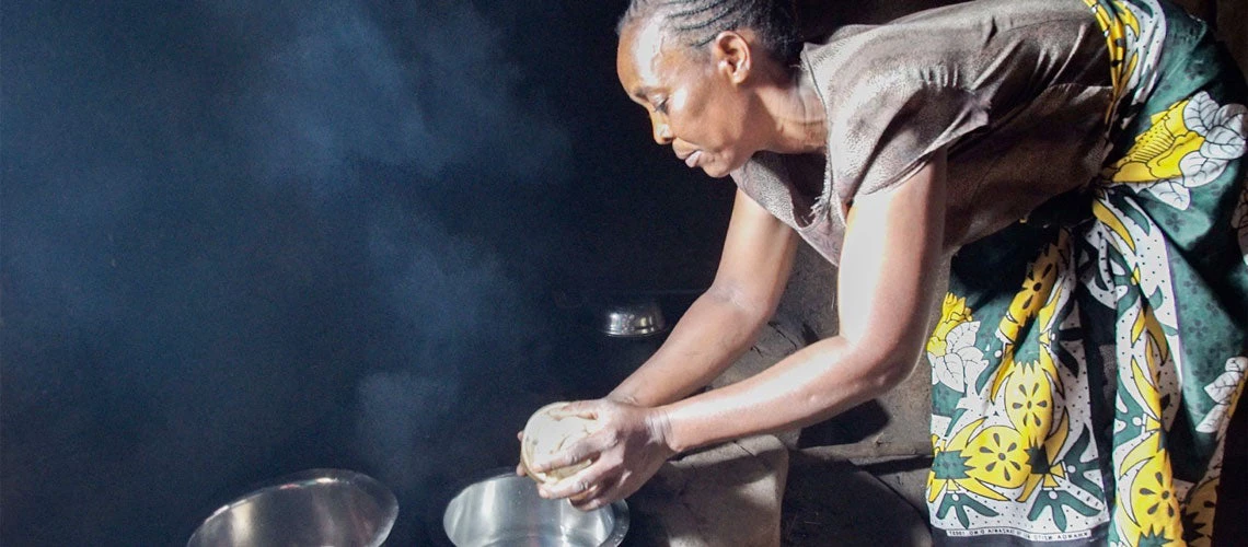 Esther Atieno prépare le dîner familial à Kisumu, au Kenya. Son poêle à bois (jiko kisasa) utilise moins de combustibles que son ancien poêle, est plus efficace, et lui donne le temps d'exercer une activité pour un revenu supplémentaire. Photo : Peter Kapuscinski / Banque mondiale