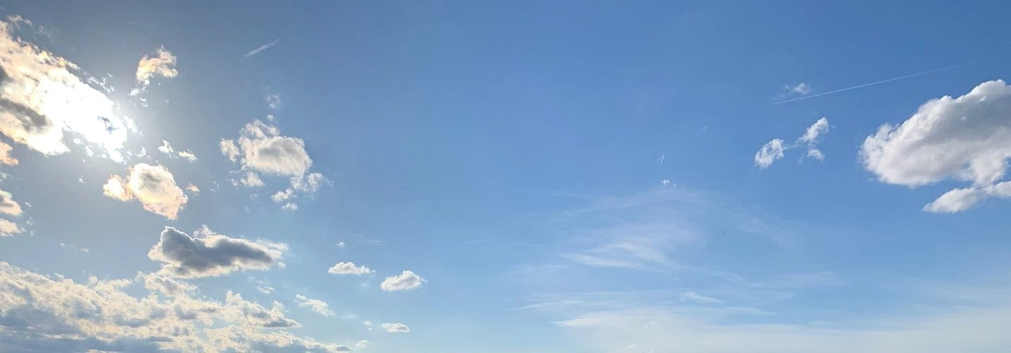 Blue skies and sunrays piercing through clouds