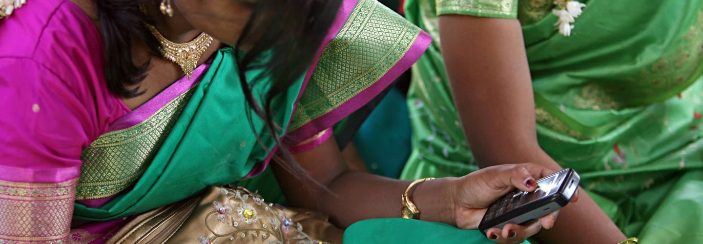 Community meeting. Girl on cellphone. Aurangabad, India