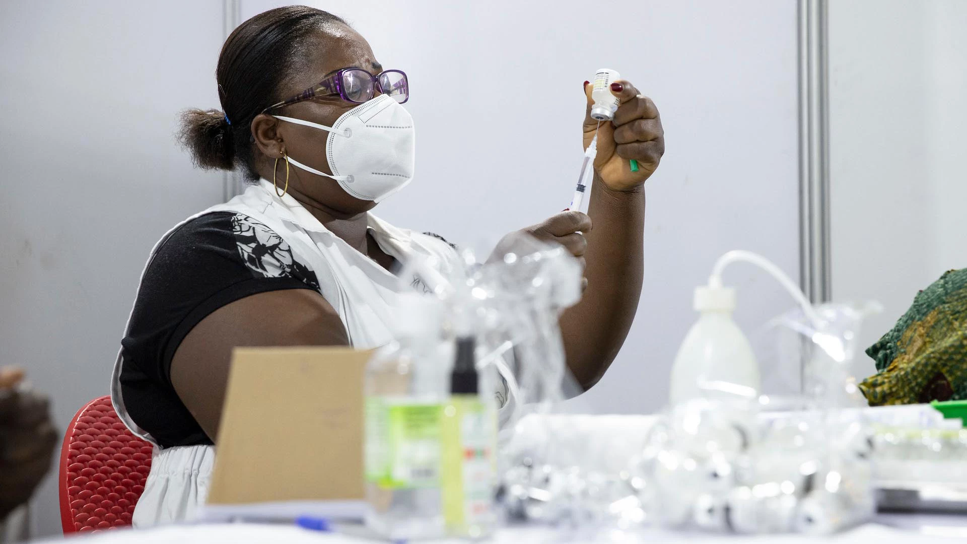 Healthcare worker prepares COVID-19 vaccination for patient.