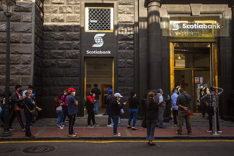 Long queue of people waiting to get into a bank branch 