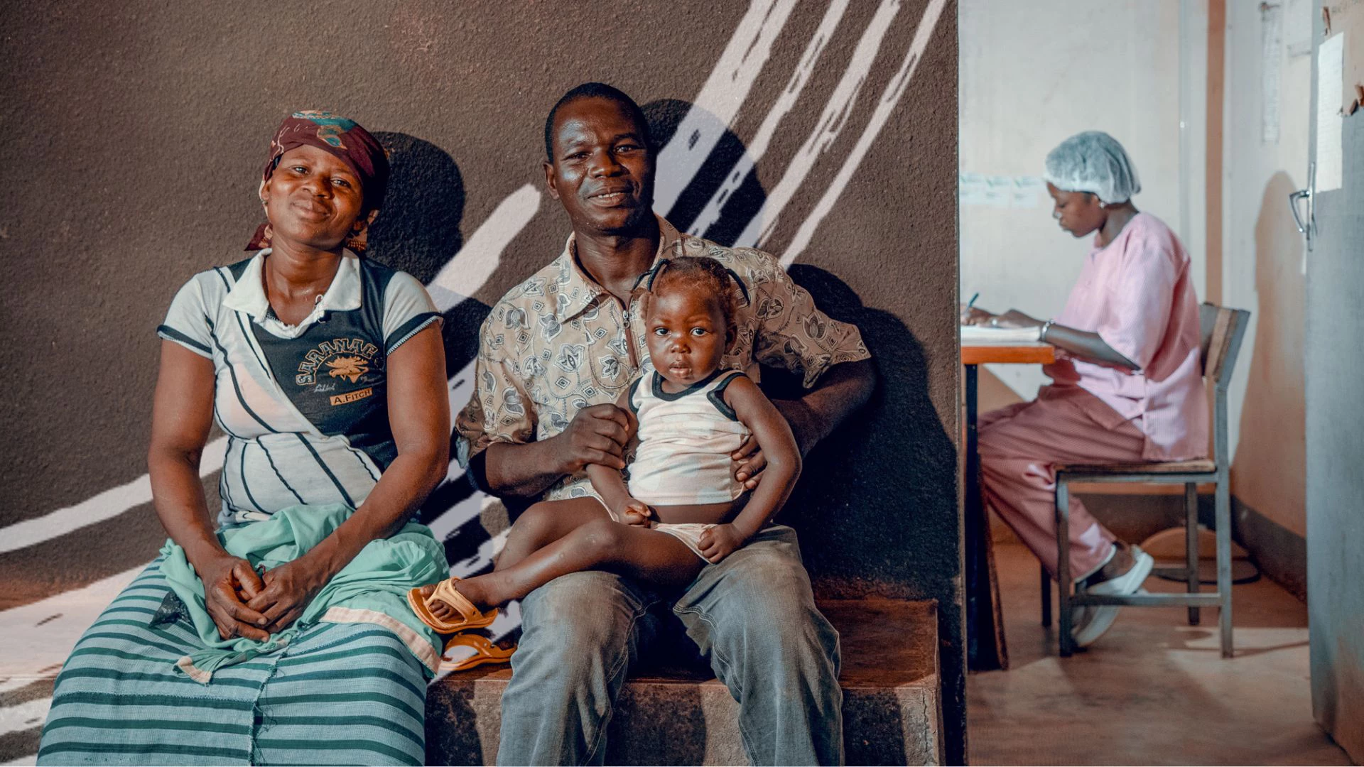 A man accompanying his wife and daughter in the waiting room of a hospital in Burkina Faso, May 14, 2019. Photo: Olivier Girard/World Bank