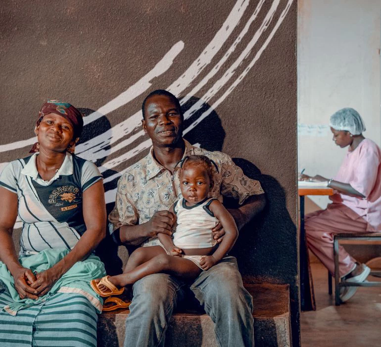 A man accompanying his wife and daughter in the waiting room of a hospital in Burkina Faso, May 14, 2019. Photo: Olivier Girard/World Bank