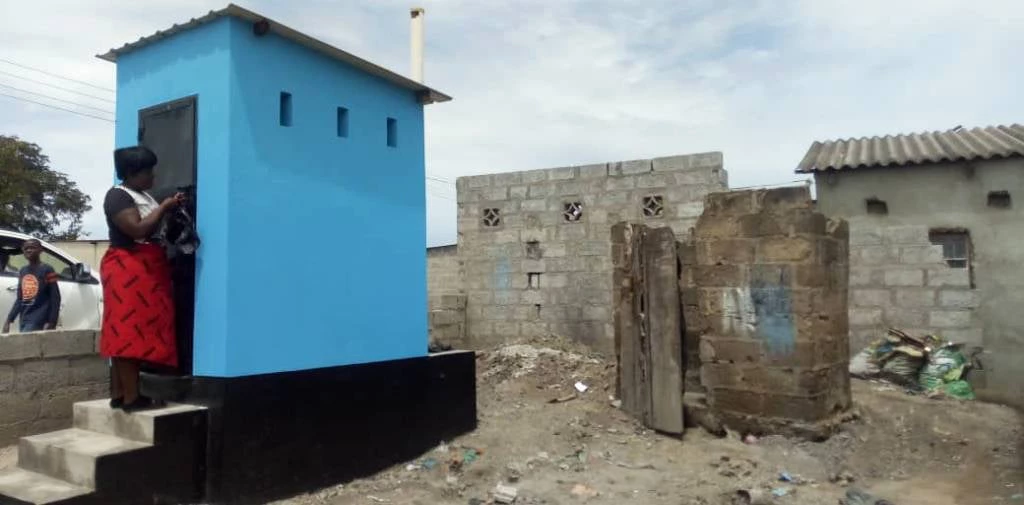 Mary Banda, accessing her new toilet in Lusaka, right next to her old toilet. Photo credit: Odete Muximpua