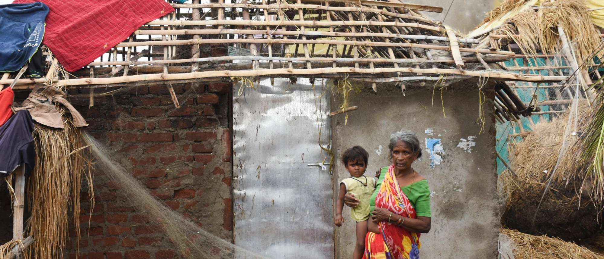 Woman holding a child following the damage aftermath of cyclonic storm FANI hitting Puri Odisha, India. © shutterstock.com