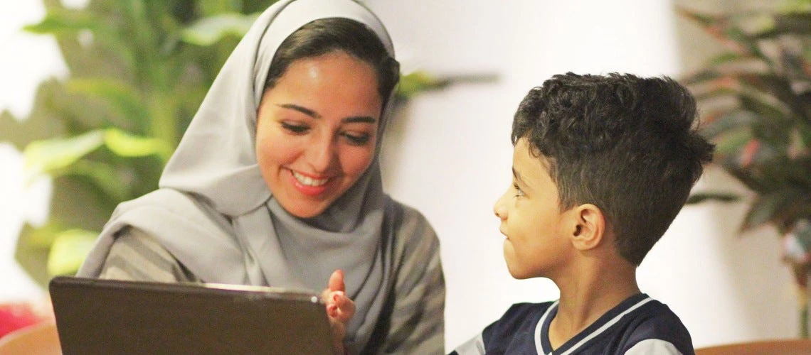 A mother with her child in front of a computer