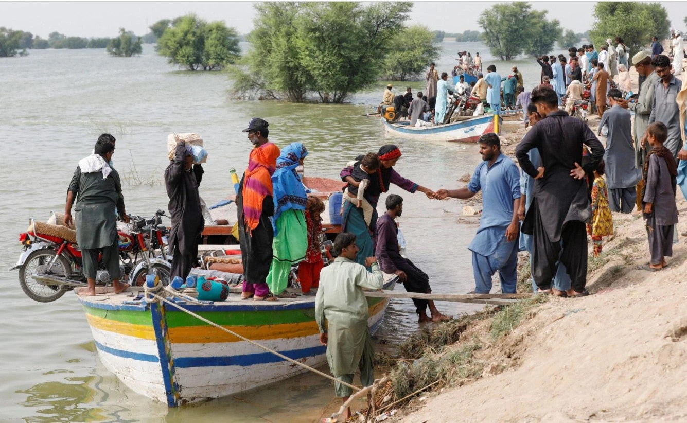 Residents use boats to travel between their villages, following rains and floods during the monsoon season in Sehwan, Pakistan, 2022. Photo: Akhtar Soomro / Alamy