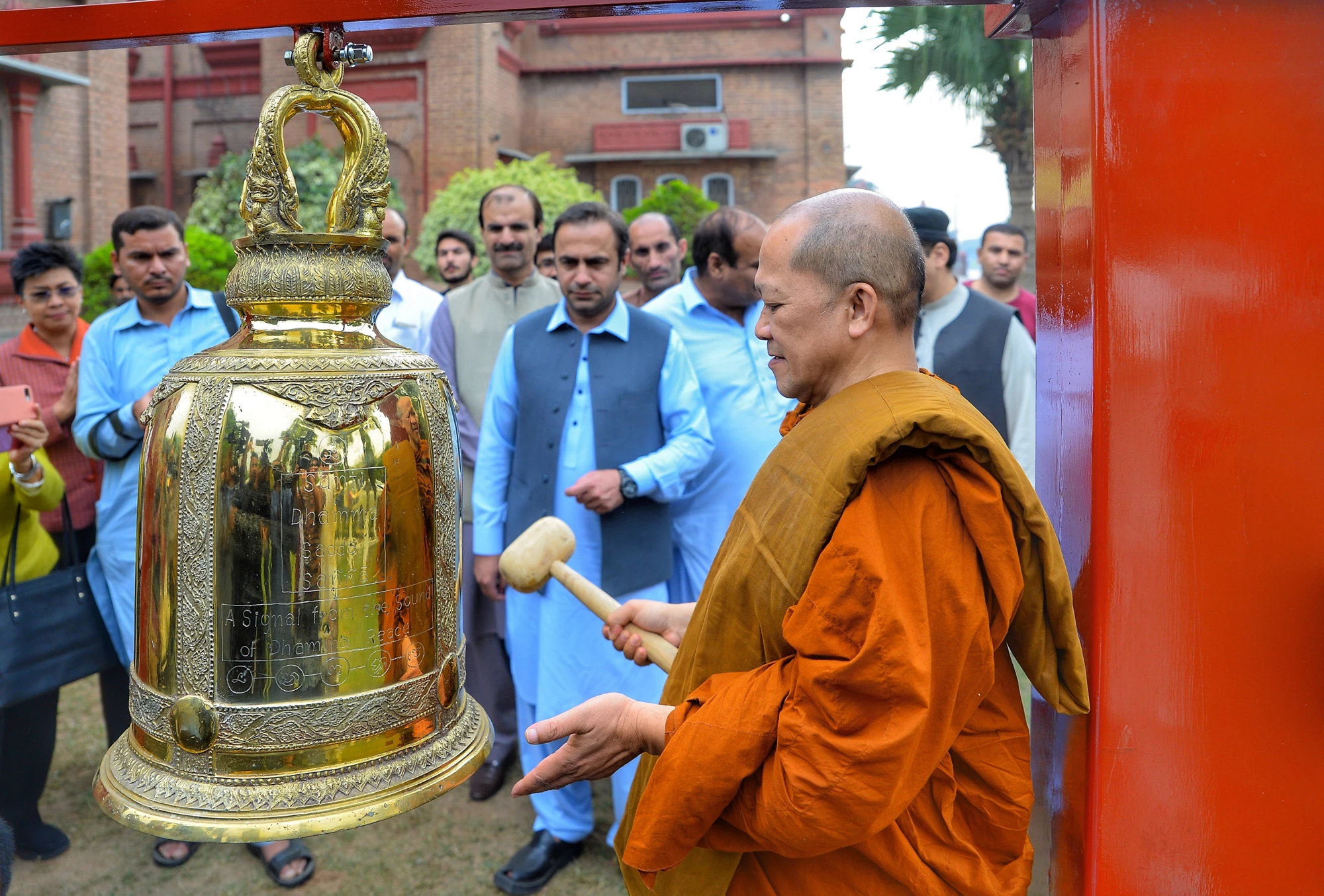 Most Venerable Arayawangso ringing the Bell of Peace in Peshawar Museum, Khyber Pakhtunkhwa, Pakistan, October 2019