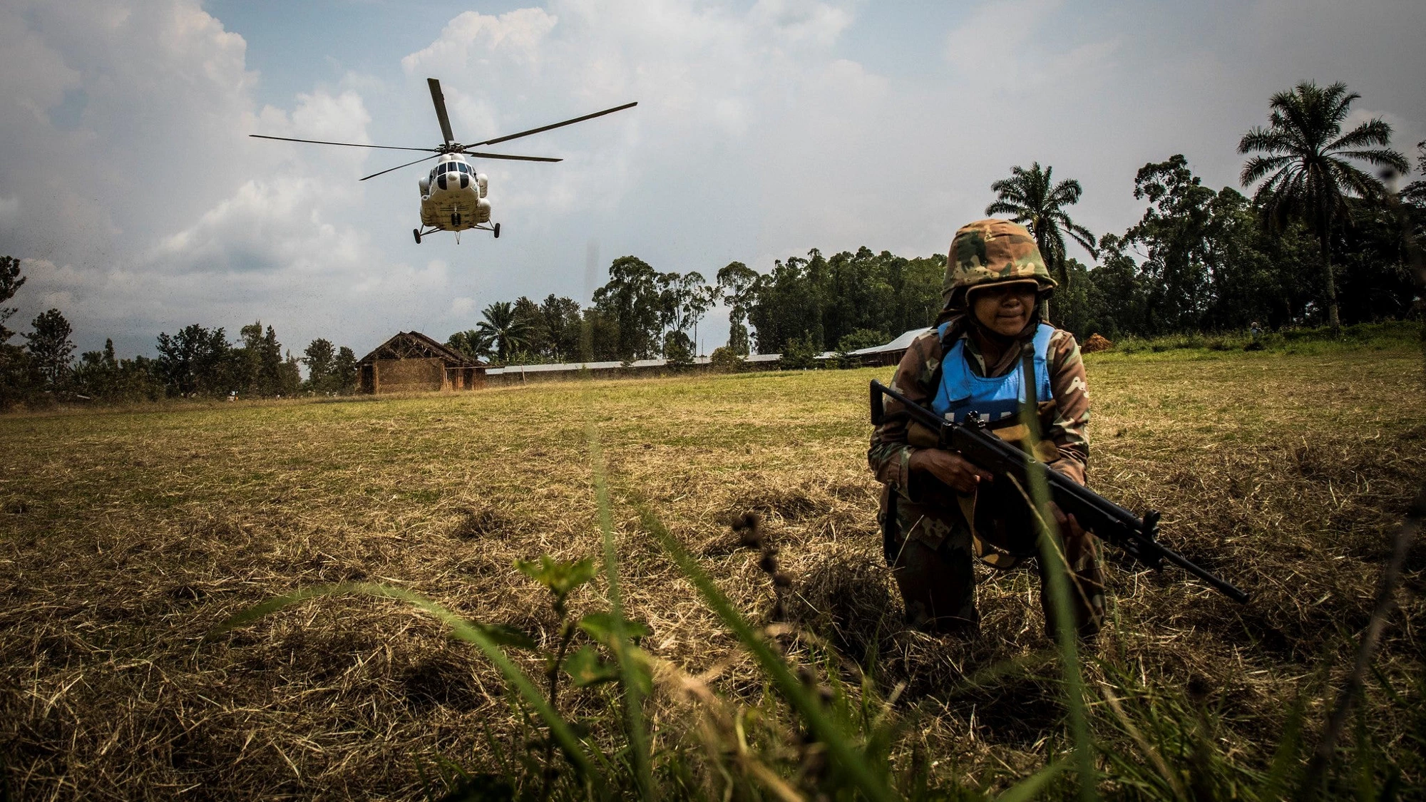 A trip to the front lines of the fight against Ebola in the Democratic Republic of Congo: A MONUSCO soldier monitors the security situation while a helicopter leaves. © World Bank/ Vincent Tremeau