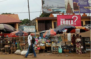 A man walks past a sign about Ebola in Conakry, Guinea. © Dominic Chavez/World Bank
