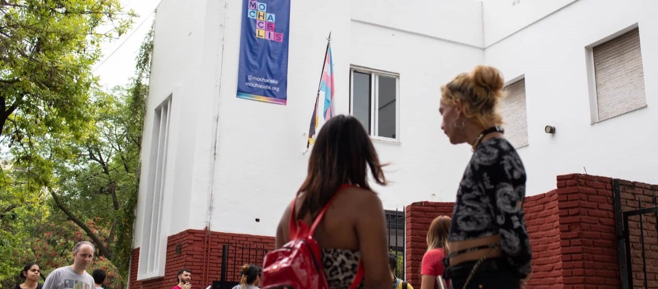 Two trans women looking at the front of the Mocha Celis Travesti-Trans Popular High School in Buenos Aires, Argentina.