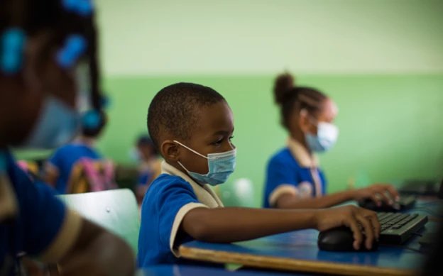 Un niño trabaja con una computadora en una escuela en la República Dominicana.