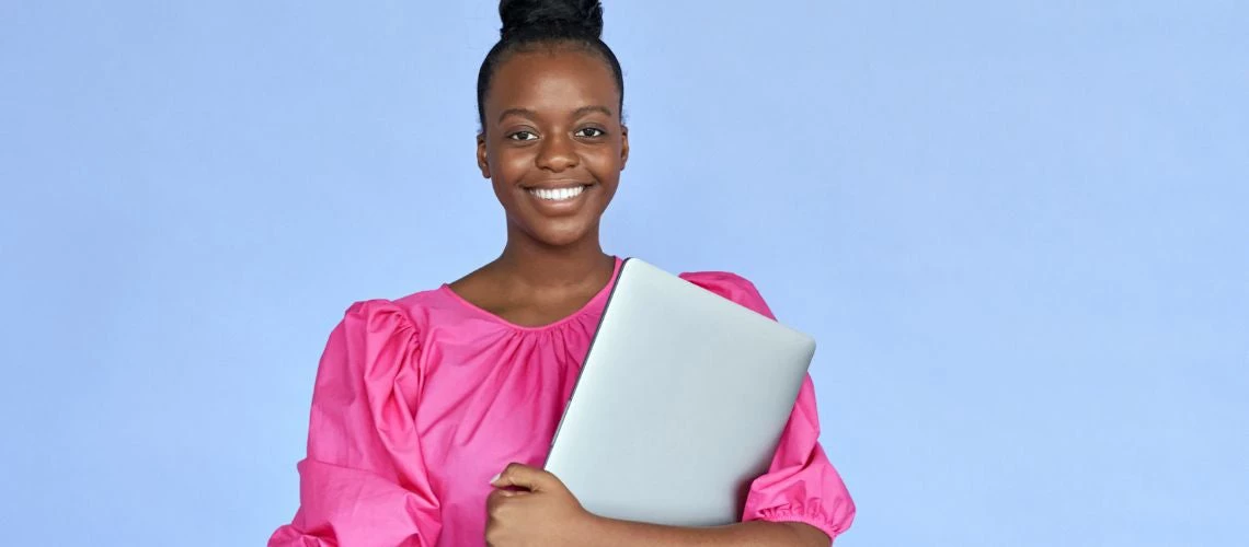 A young African girl holding a laptop is determined to solve pressing local and global challenges by being exposed to technology and gaining digital skills.