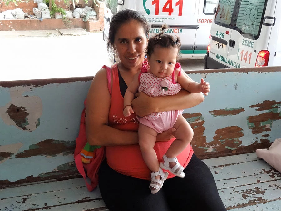 Paraguayan woman holding a baby girl.