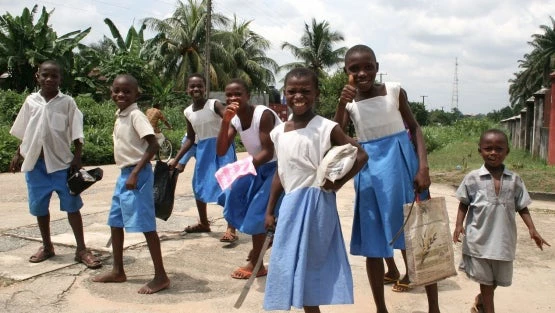 Un grupo de niños sonríe a la cámara tras salir de la escuela para ir a trabajar al campo en Nigeria. 