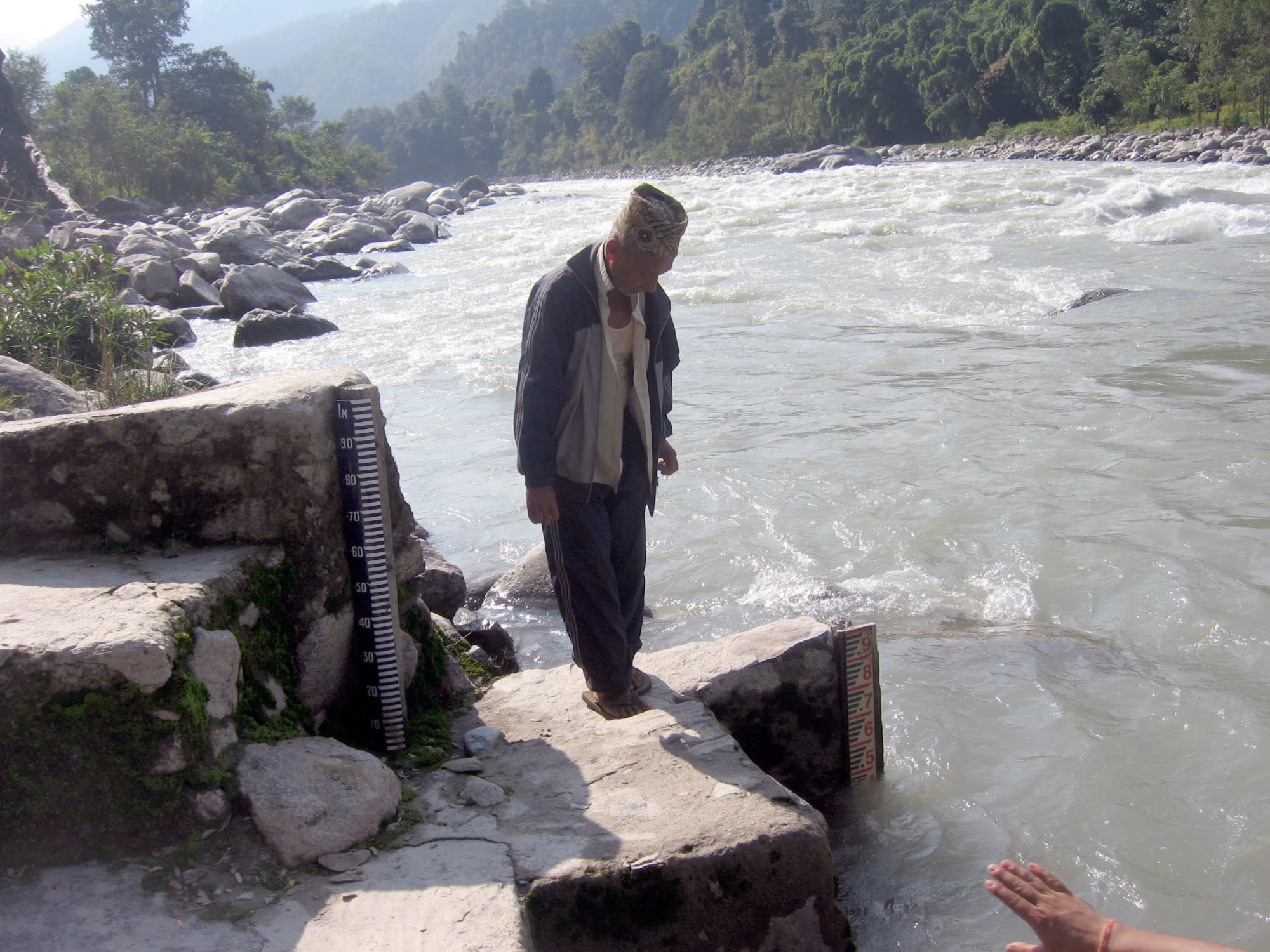 A man checking the water level of a local river in Nepal. Photo: World Bank Group/Vladimir Tsirkunov