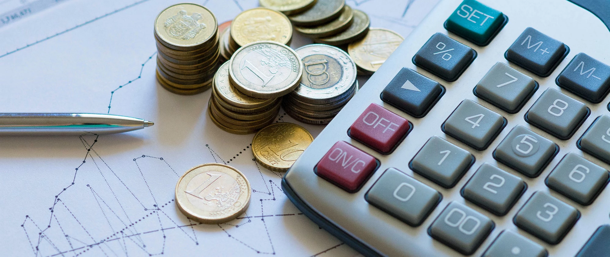 Finance tools: Pen, charts, currency, and calculator. | © shutterstock.com