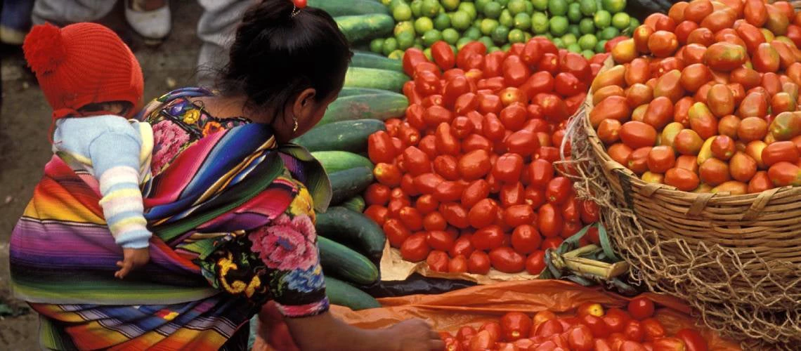 A woman buying tomatoes at a market in Guatemala. Photo: Curt Carnemark/World Bank