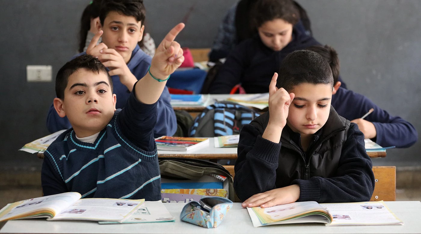 Students at the Second Bourj Hammoud Public School in Beirut, Lebanon, raise their hands to answer their teachers questions. © Dominic Chavez/World Bank