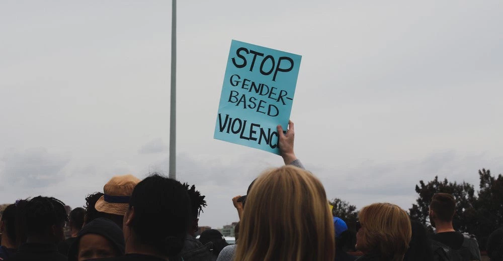 A protester holds up a sign at a demonstration against sexual violence.
