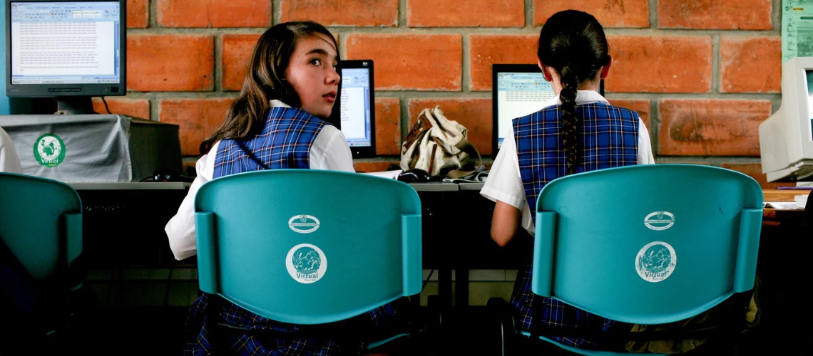 Photo of two school girls in uniform, studying.