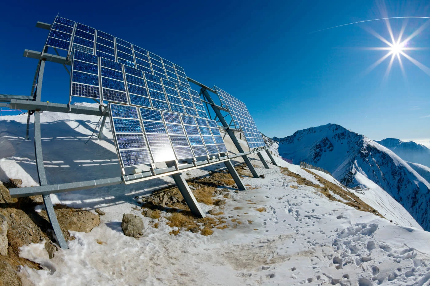 A solar panel installed on a snow-covered mountain reflects the sunlight