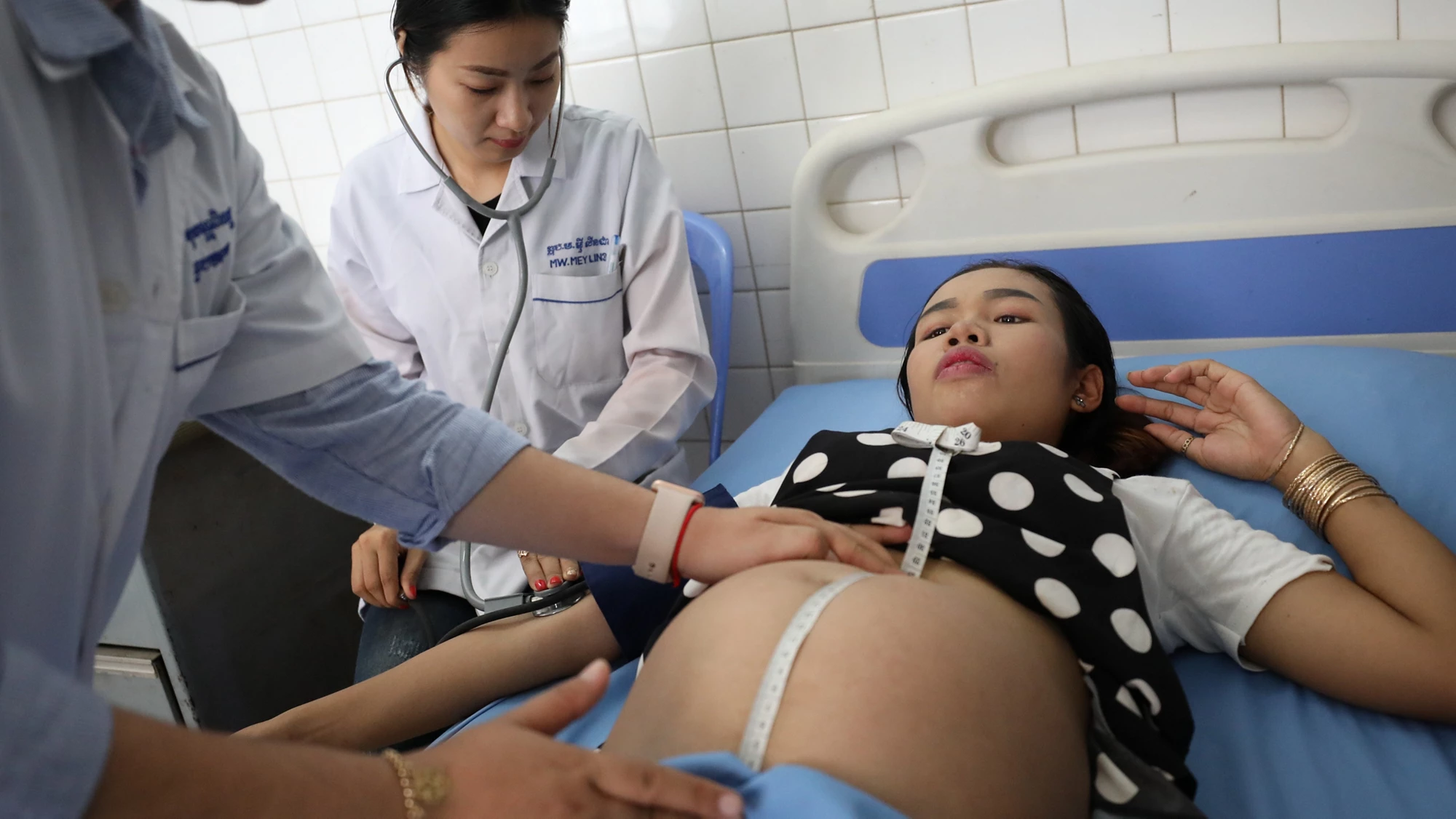 Thea Sovan Pita, Secondary Midwife (far left) assists a pregnant mother during a antenatal care examination at Teuk Thla Health Center in Phnom Penh, Cambodia.