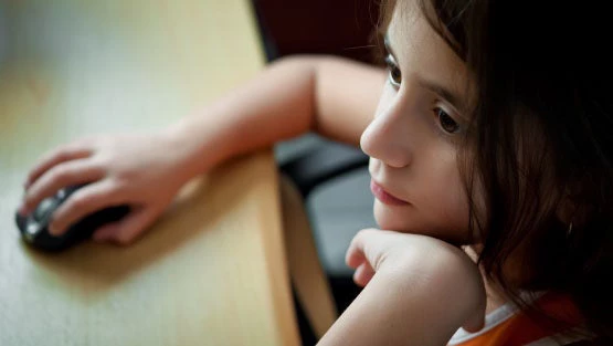 Young girl sitting at her computer.