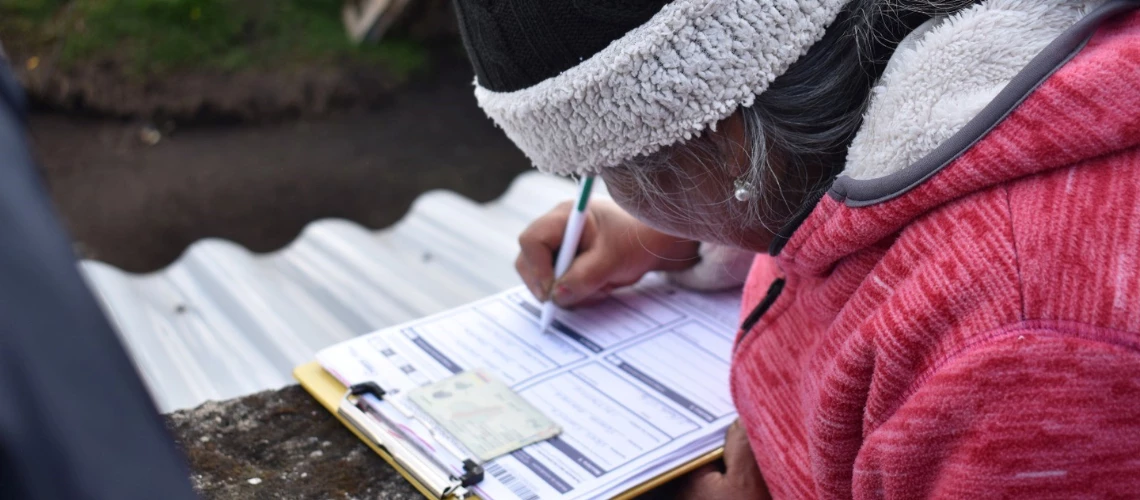 Mujer ecuatoriana llenado un formulario del sitema de registros sociales. 