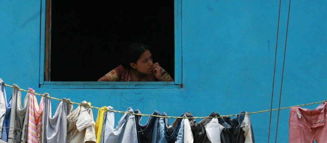 Joven mirando por la ventana en Quiche, Guatemala. 