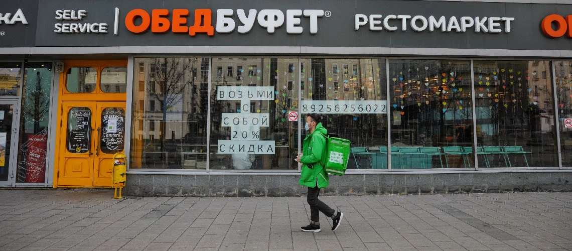 Moscow, Russia - April 02: A food delivery courier on the street during the period of self-isolation of citizens due to the coronavirus pandemic (COVID-19). © Julia Perova/Shutterstock