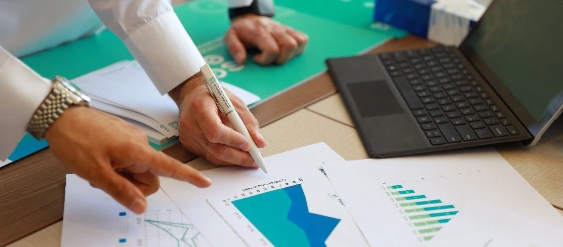 Pollsters point to and analyze charts scattered on a desk.