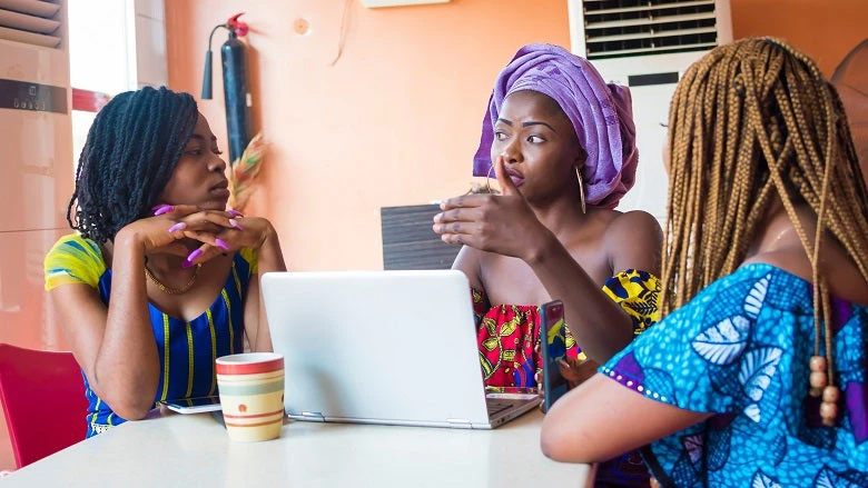 Three young African women discussing business