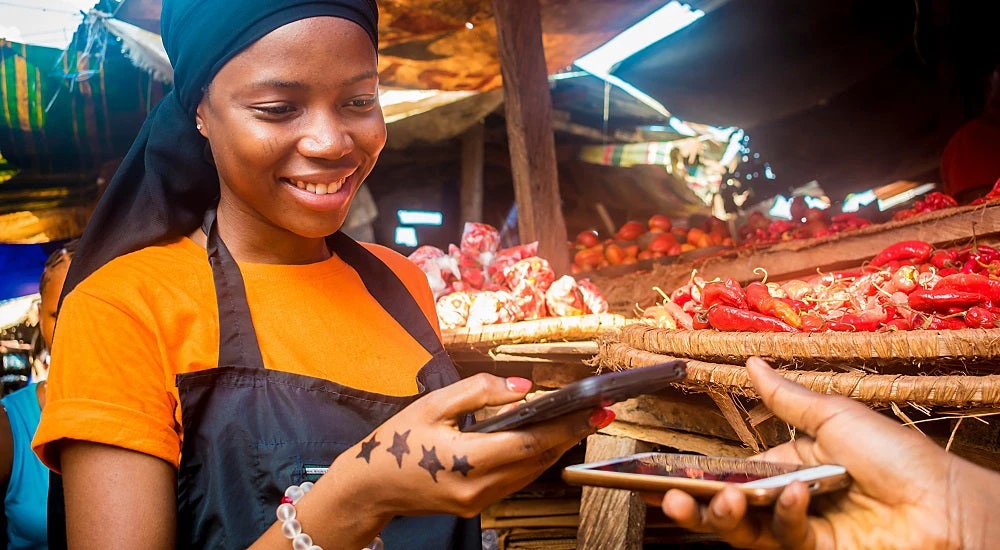 young african woman receiving payment via mobile phone transfer