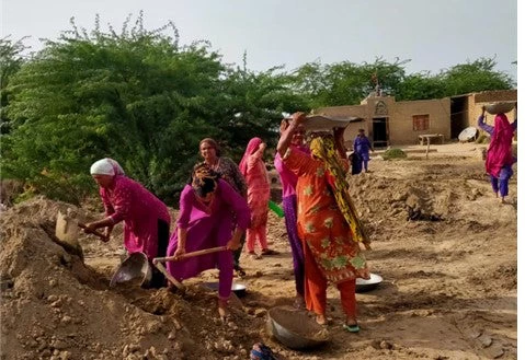 Women working to build the community access road.