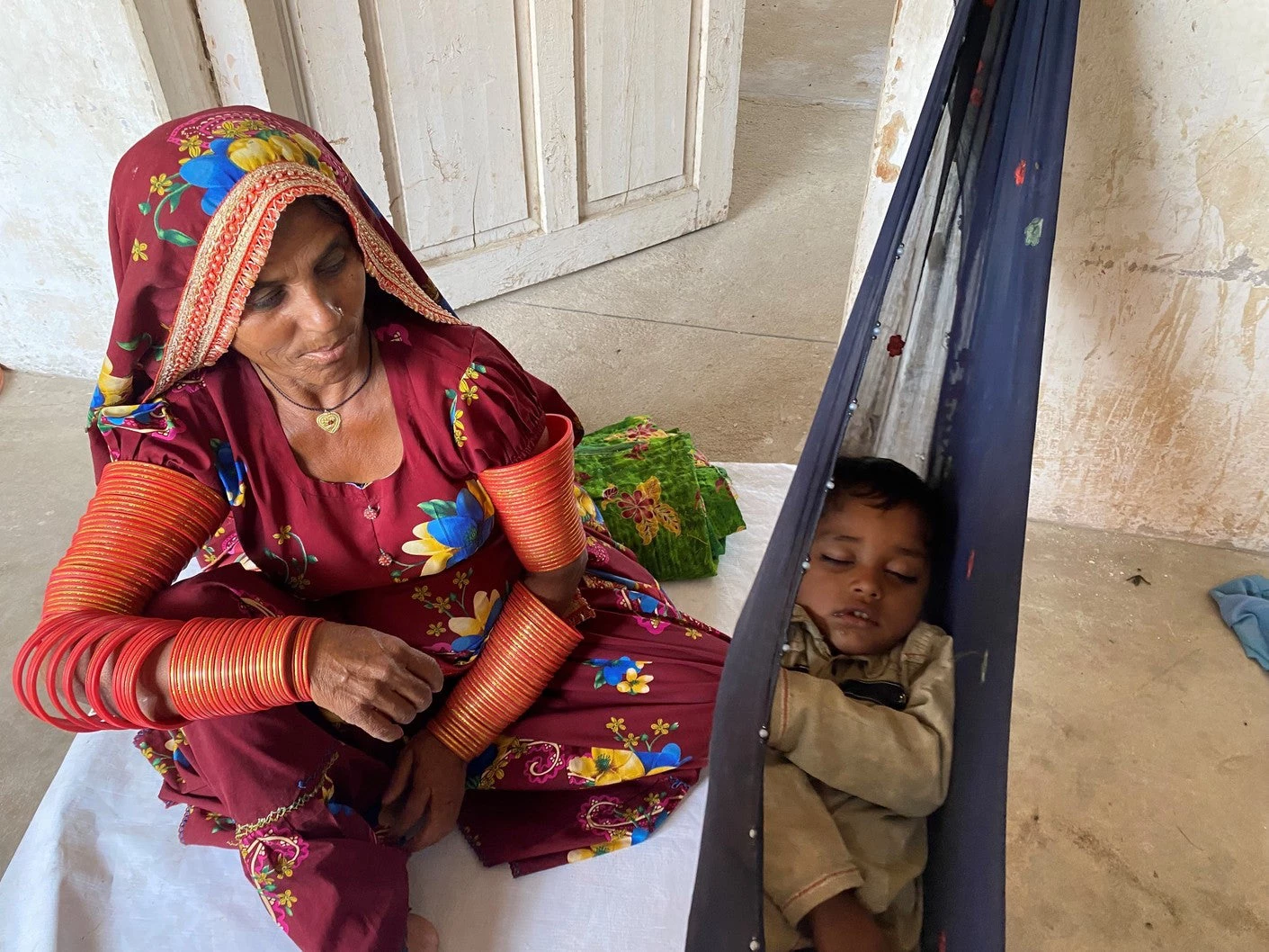  A grandmother takes care of the child, while the mother works in the fields in Tharparkar, Pakistan.