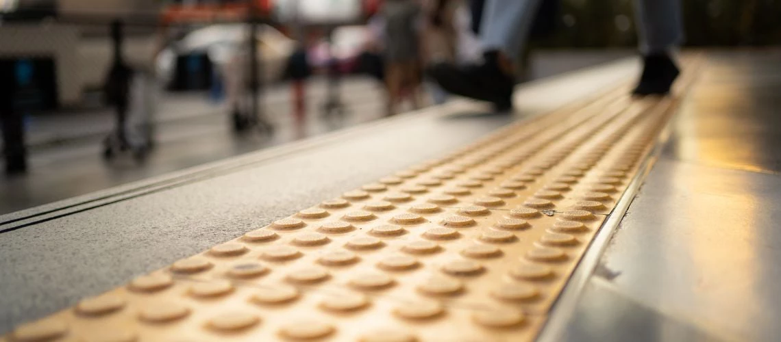 A pedestrian walking on a street that's been designed for people with disabilities