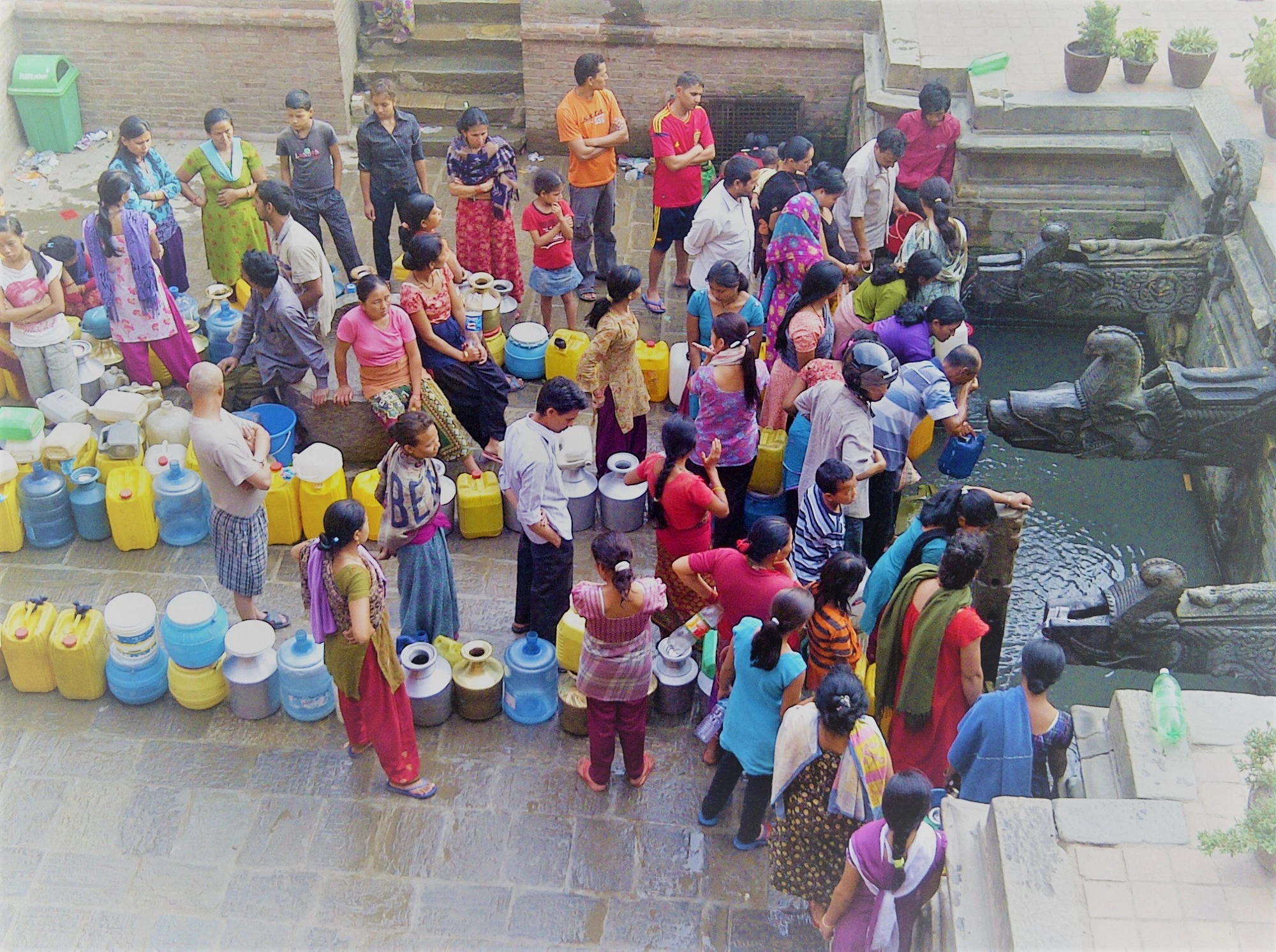  Un groupe de gens rassemblés autour d'une fontaine d'eau potable (Crédit photo : Improved or Not Improved ? Water / Sanitation Photo Catalogue / Flickr CC)