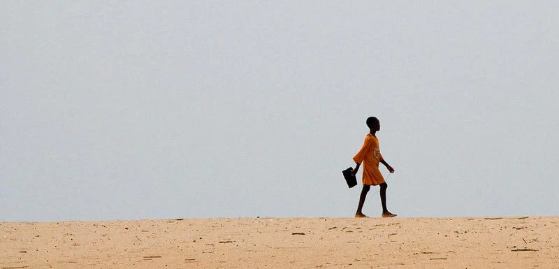 Une jeune fille se rend à l'école à pied.