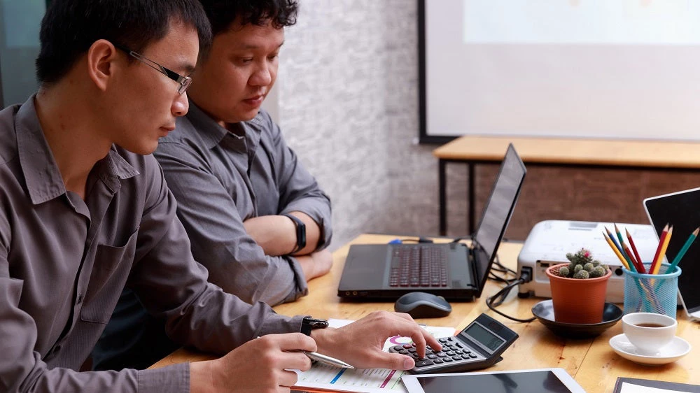 Two Asian men accounting, Jat306/Shutterstock