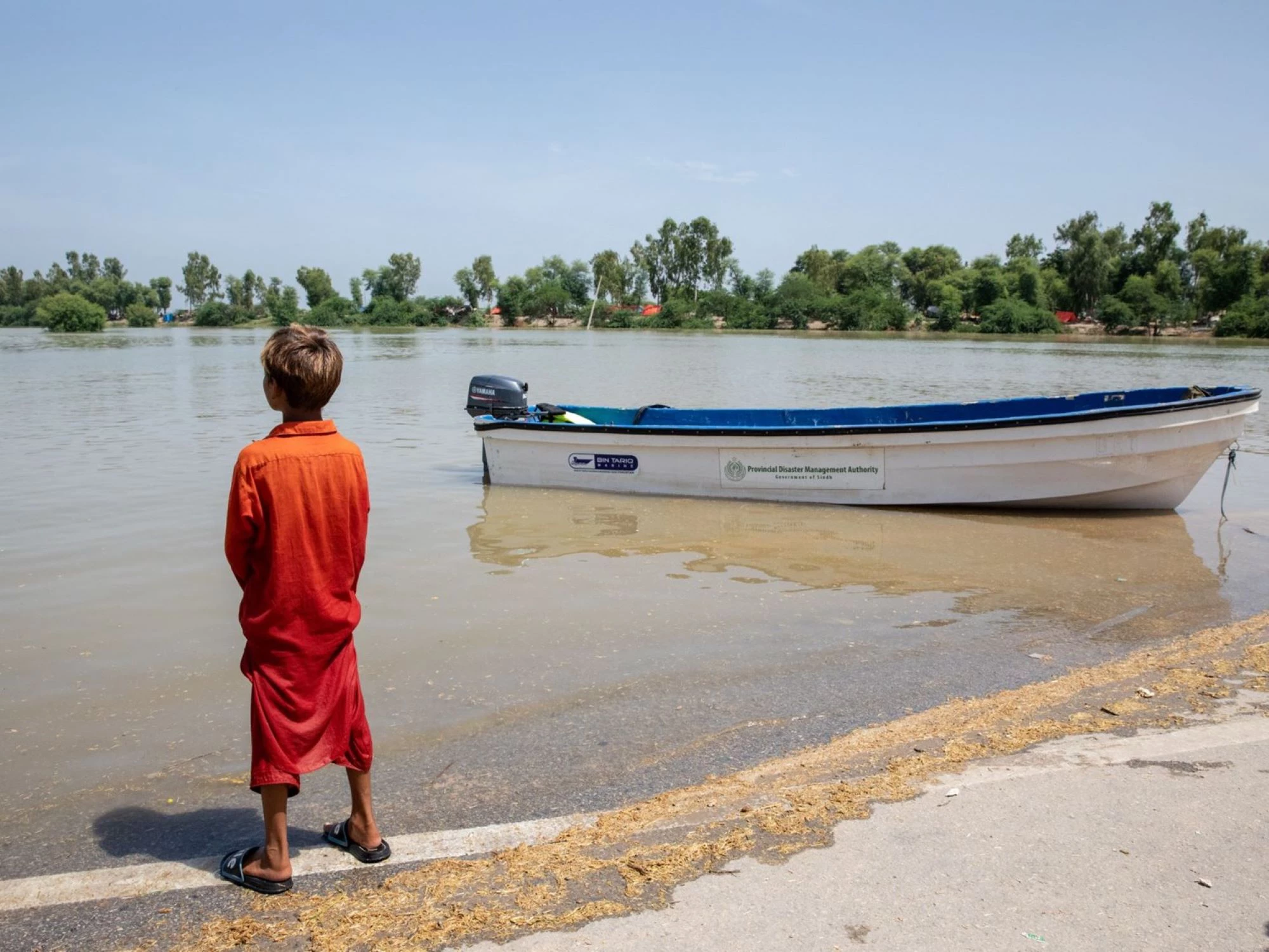 Boy looking at the immensity of the 2022 floods in Sindh province. Pakistan.