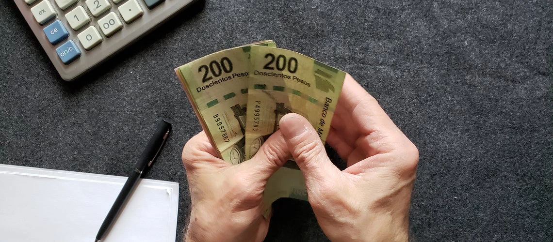Man holding Mexican banknotes