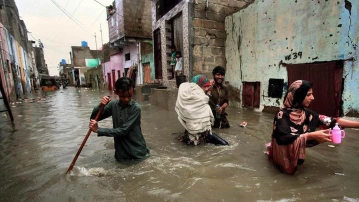 Citizens of Karachi wading through flooded streets during the monsoon surge