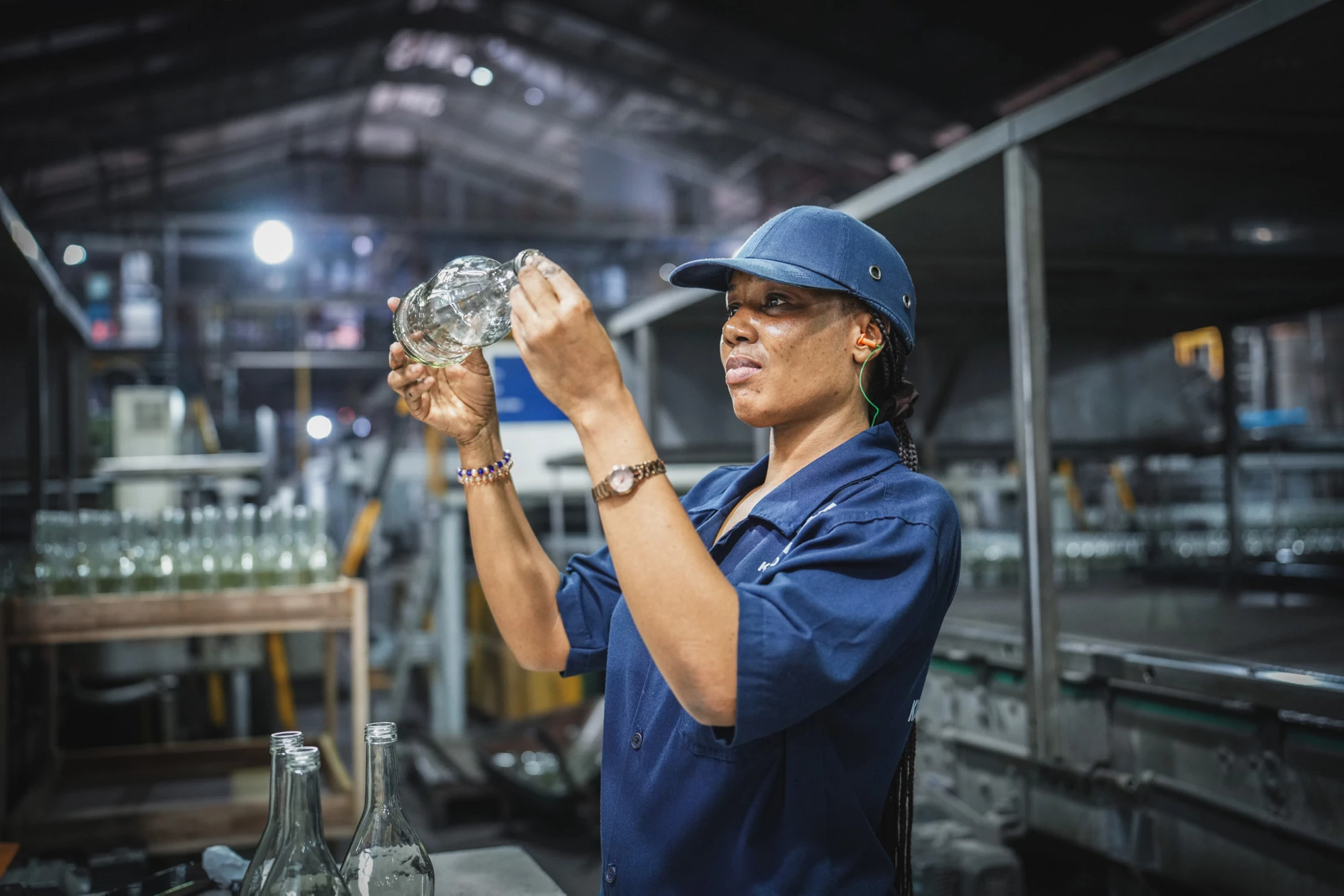 A worker inspecting a glass bottle at the Kioo Glass Factory in Tanzania. Photo: Maria Galang/IFC
