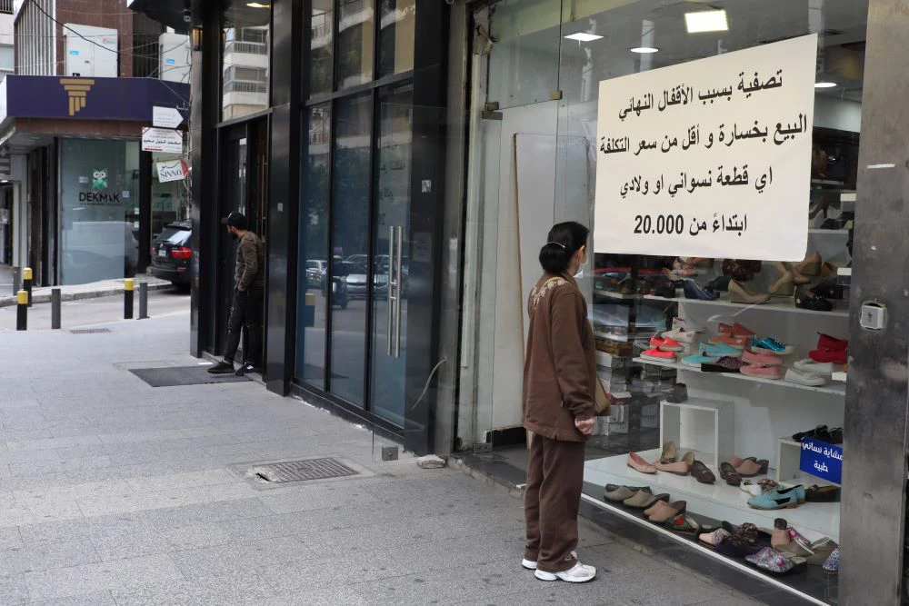 Woman looking at shoe shop with "Closing Shop" sign on the window in Beirut, Lebanon, during COVID-19. (Photo: Mohamed Azakir)